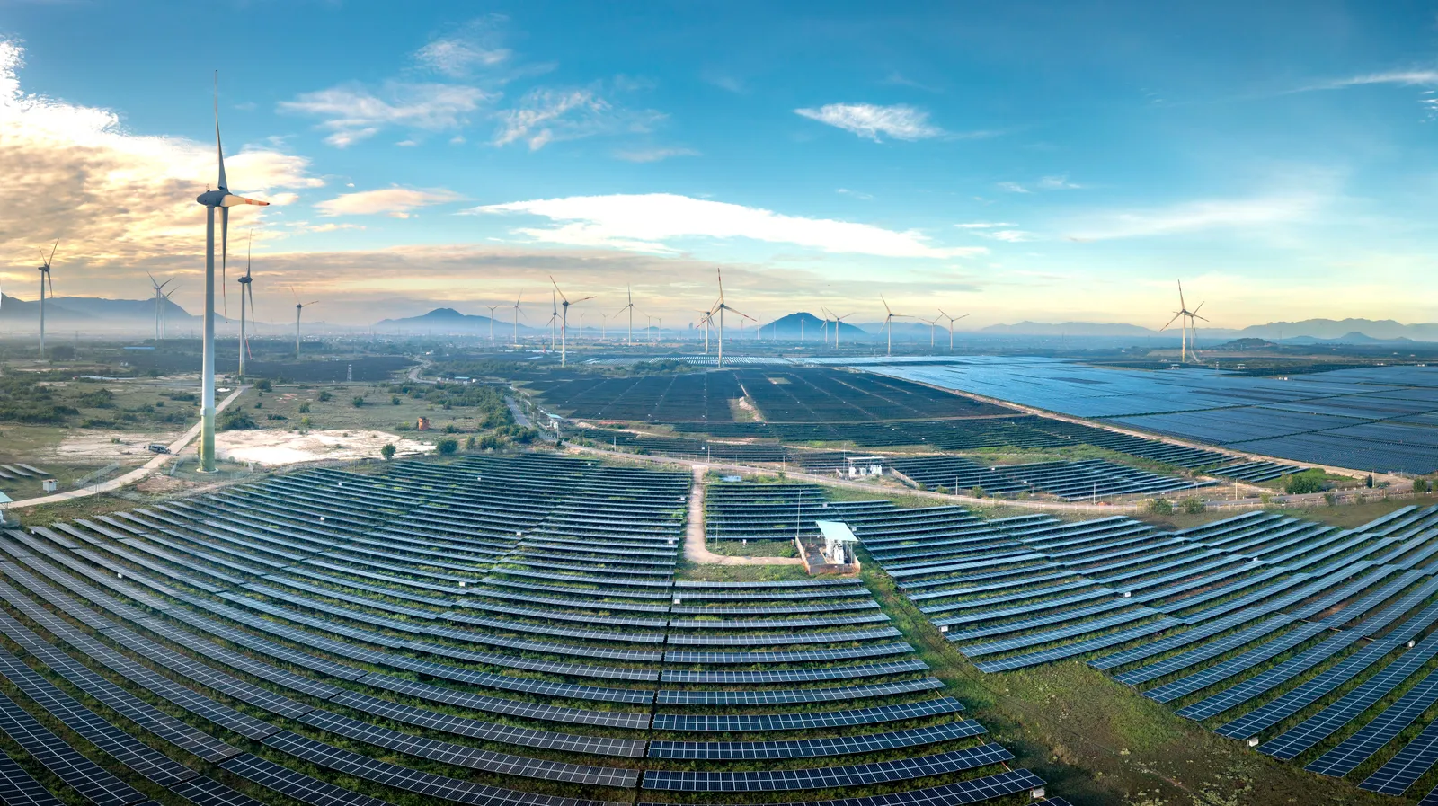 Uitgestrekt zonnepark met windturbines